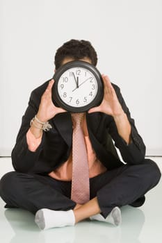 Businessman hiding his face with a clock