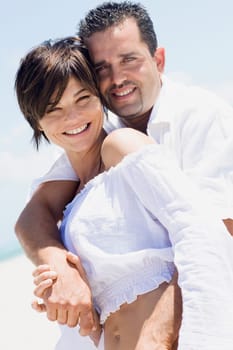Portrait of a mid adult couple standing on the beach and smiling