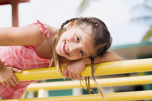 Portrait of a girl on a jungle gym and smiling