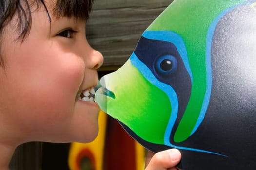Close-up of a girl biting fish toy