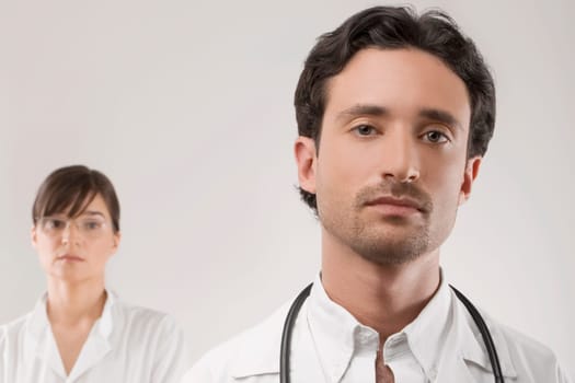 Close_up of a male doctor with a female doctor behind him