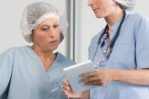 Two male surgeons discussing a medical report