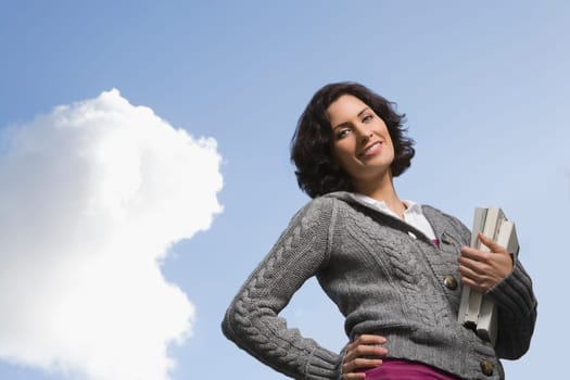 Low angle view of a young woman holding textbooks