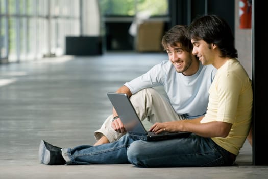 Two young men working on a laptop
