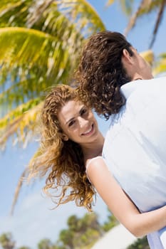 Portrait of a mid adult woman walking with her arm around a mid adult man and smiling