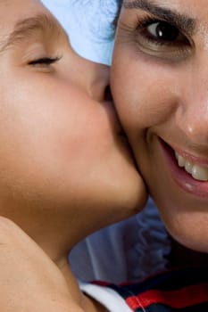 Close-up of a boy kissing his mother