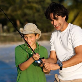 Father and his son fishing on the beach