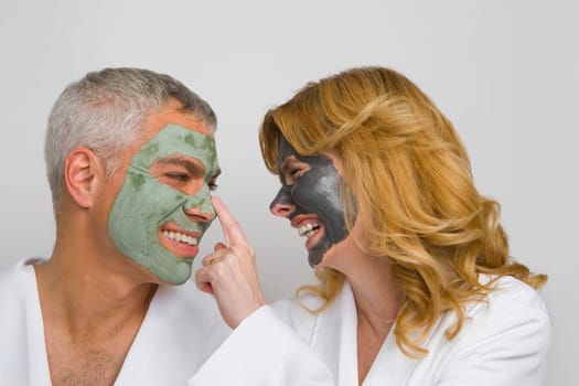 Close_up of a mature couple wearing facial masks and smiling