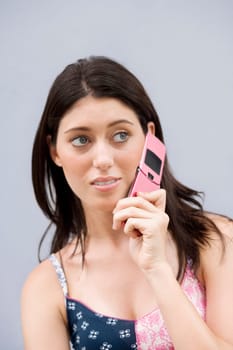 Close-up of a teenage girl using a mobile phone and looking away