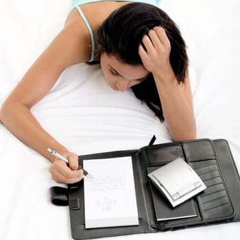 High angle view of a young woman writing in a note pad