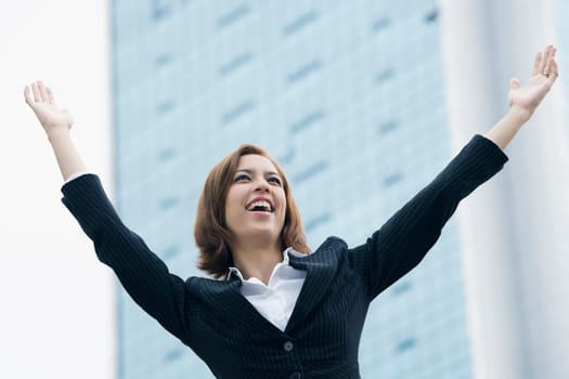 Close_up of a businesswoman smiling with her arms raised