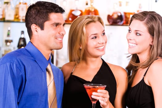 Close-up of two young women and a mid adult man in a bar
