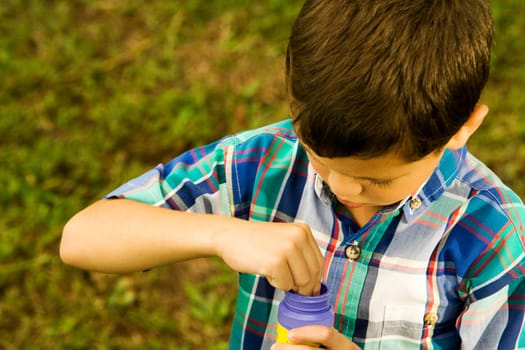 High angle view of a boy holding a plastic bottle