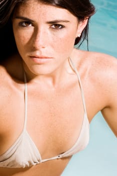Portrait of a young woman sitting at the poolside