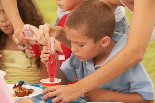 Two boys and a girl drinking from a cup