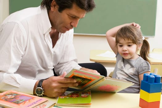 Male teacher teaching his student in a classroom