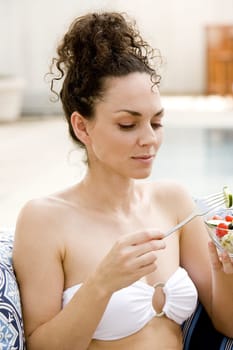 Close-up of a young woman eating fruit salad