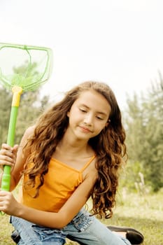 Close-up of a girl sitting holding a butterfly net