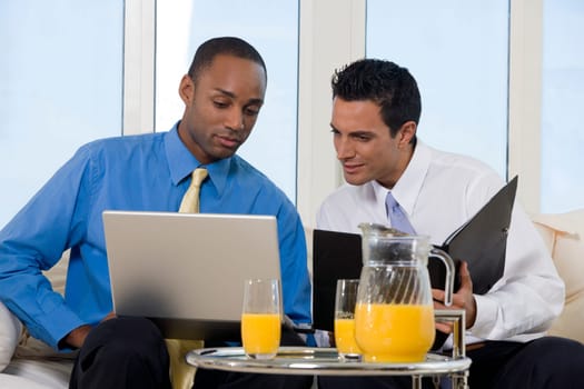 Close-up of two businessmen looking at a laptop