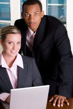 Portrait of a businessman and a businesswoman in front of a laptop