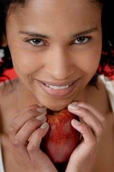 Portrait of a young woman holding an apple under her chin