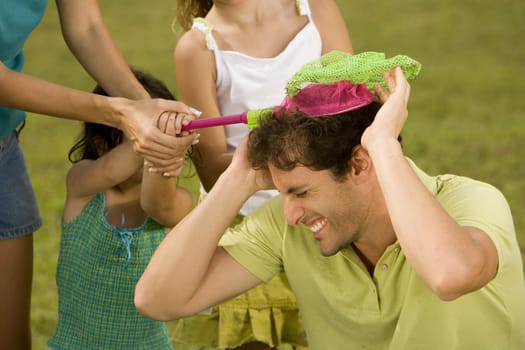 Close-up of a mid adult man playing with his family