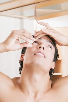 Close-up of a young man pouring eyedrops into his eyes