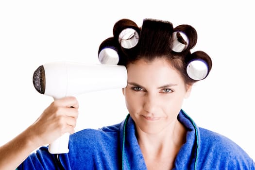 Portrait of a young woman with curlers in her hair holding a hairdryer