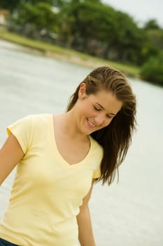 Close-up of a teenage girl walking on the beach smiling
