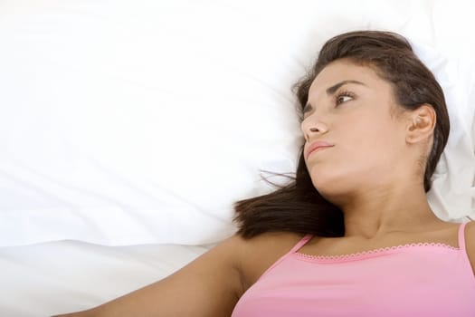 Close-up of a young woman lying down on a bed