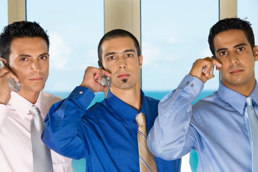Portrait of three businessmen talking on mobile phones