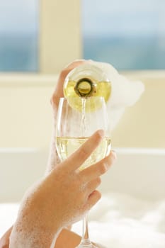 Close-up of a womanŽs hand pouring champagne in champagne flute