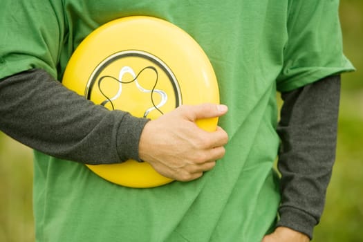 Mid section view of a person holding a plastic disc