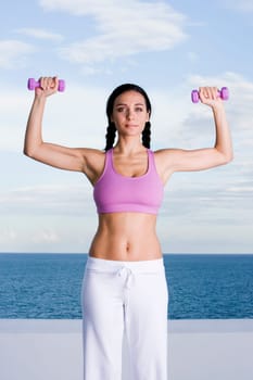 Portrait of a young woman exercising with dumbbells