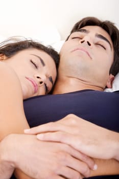 Close-up of a young couple sleeping on a bed