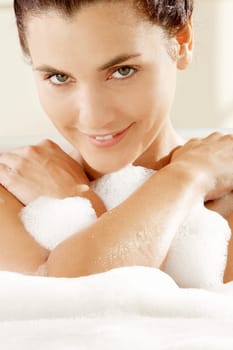 Portrait of a young woman smiling in a bathtub