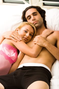 Portrait of a young couple lying on the bed