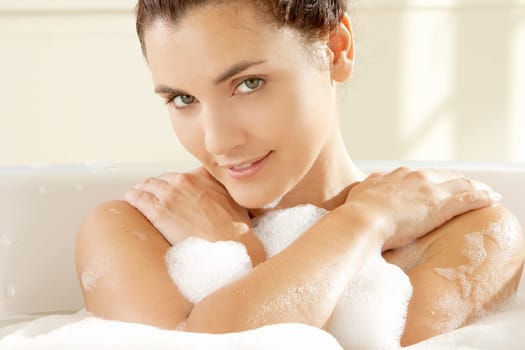 Portrait of a young woman smiling in a bathtub