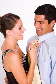 Side profile of a young woman adjusting a mid adult manŽs tie