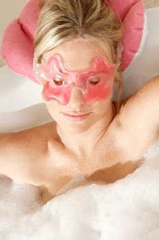High angle view of a young woman in a bathtub with her eyes closed