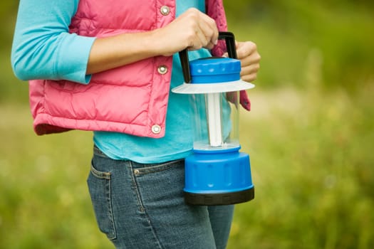 Mid section view of a woman holding a lantern