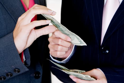 Mid section view of two businesswomen holding dollar bills