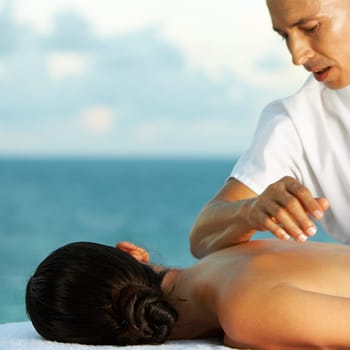 Massage therapist massaging a womanŽs back