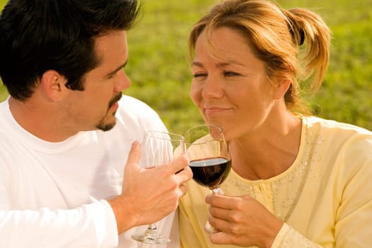 Close-up of a mature man and a young woman toasting with wine