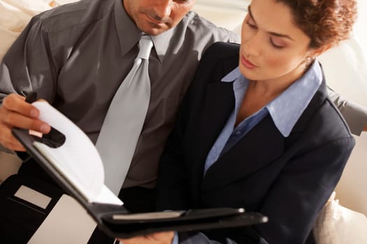 Close-up of a businesswoman with a businessman holding a file