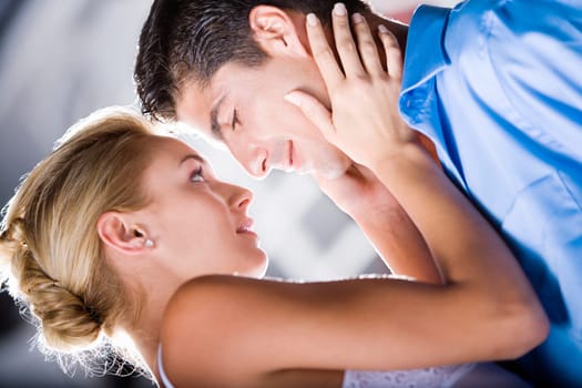 Side profile of a young woman holding the face of a mid adult man