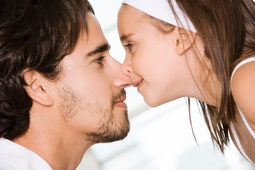 Side profile of a father and his daughter nuzzling