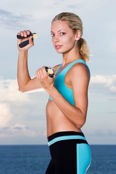 Portrait of a young woman squeezing hand grips