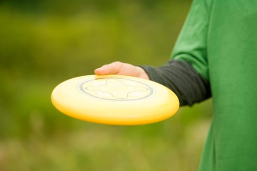 Mid section view of a person holding a plastic disc