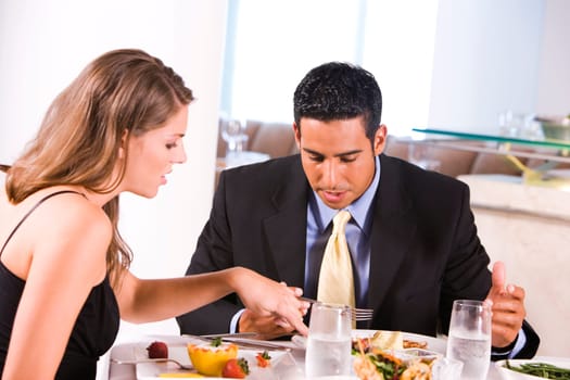 Side profile of a young woman and a mid adult man eating in a restaurant